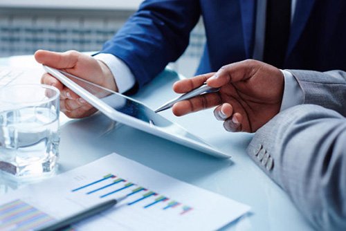 Foto de uma pessol  mostrando algo em um ipad ao outro